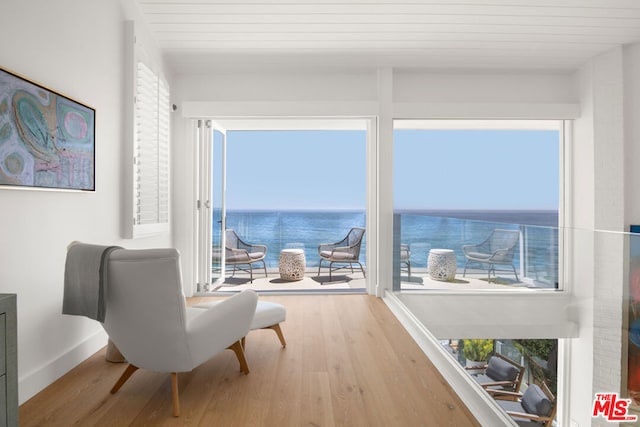 sitting room with wood-type flooring and a water view