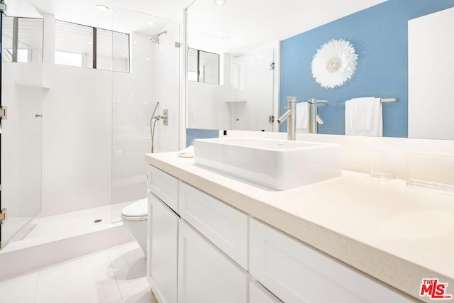 bathroom with a shower with door, toilet, tile patterned floors, and vanity