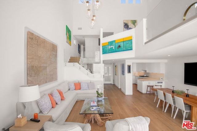 living room with a high ceiling and light hardwood / wood-style floors