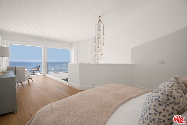 bedroom featuring hardwood / wood-style flooring, wooden ceiling, and a water view