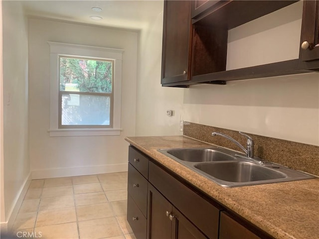 kitchen featuring sink, dark brown cabinets, and light tile patterned floors