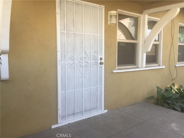 view of exterior entry featuring a patio area