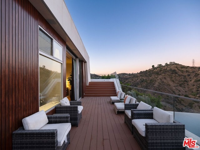 deck at dusk with a mountain view and an outdoor hangout area