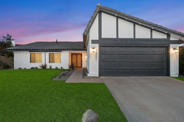 view of front of home with a garage and a lawn