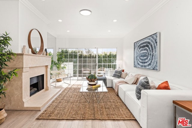 living room featuring a premium fireplace, crown molding, and light hardwood / wood-style flooring