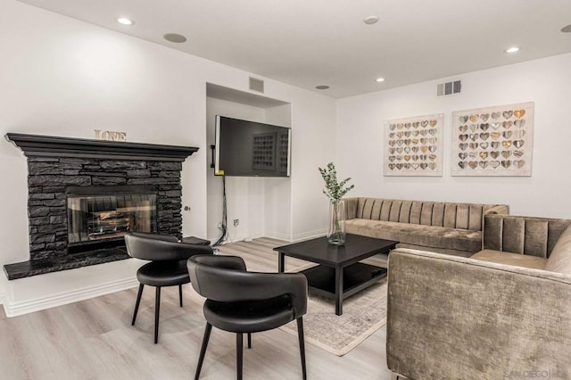 living room featuring a fireplace and light wood-type flooring