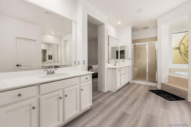 bathroom with independent shower and bath, vanity, and wood-type flooring