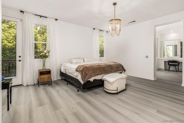 bedroom with access to exterior, an inviting chandelier, and light hardwood / wood-style floors