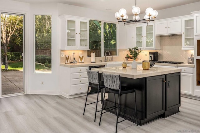 kitchen featuring white cabinetry, hanging light fixtures, light wood-type flooring, and a kitchen island