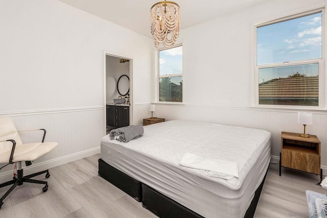 bedroom featuring a notable chandelier and light wood-type flooring