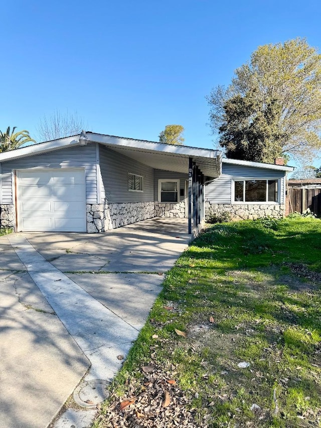 single story home featuring a carport, a garage, and a front lawn