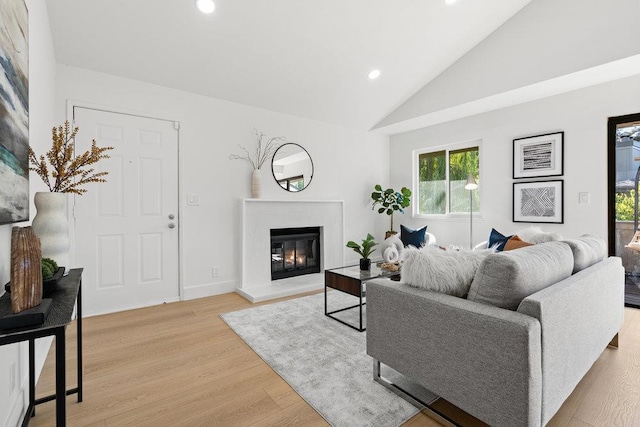 living room featuring high vaulted ceiling and light wood-type flooring