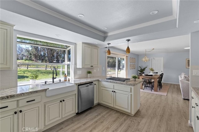 kitchen featuring appliances with stainless steel finishes, tasteful backsplash, sink, hanging light fixtures, and kitchen peninsula