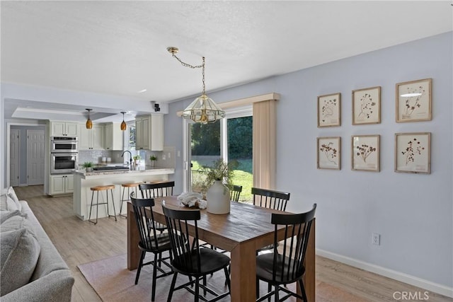 dining area featuring light hardwood / wood-style flooring and an inviting chandelier