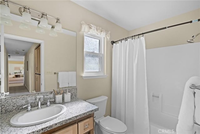 bathroom featuring toilet, vanity, and a shower with shower curtain