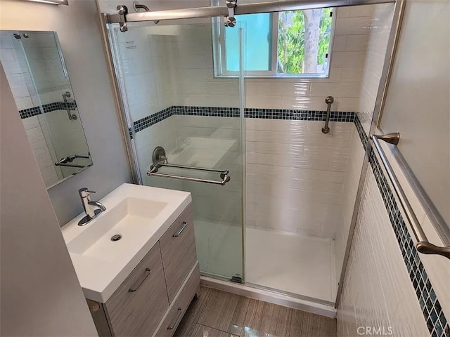 bathroom featuring vanity and a shower with door