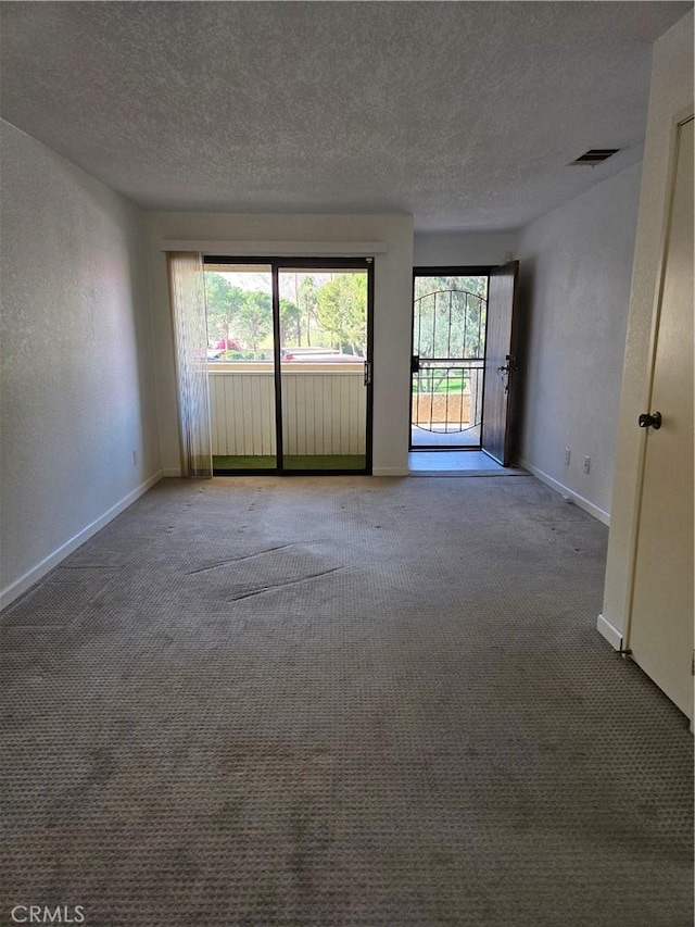 carpeted spare room with a textured ceiling