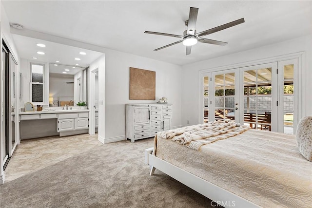 carpeted bedroom featuring sink, ceiling fan, access to exterior, ensuite bathroom, and french doors