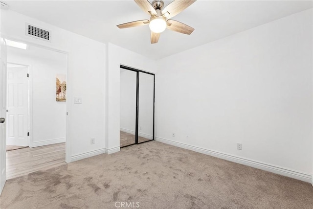 unfurnished bedroom featuring light colored carpet, ceiling fan, and a closet