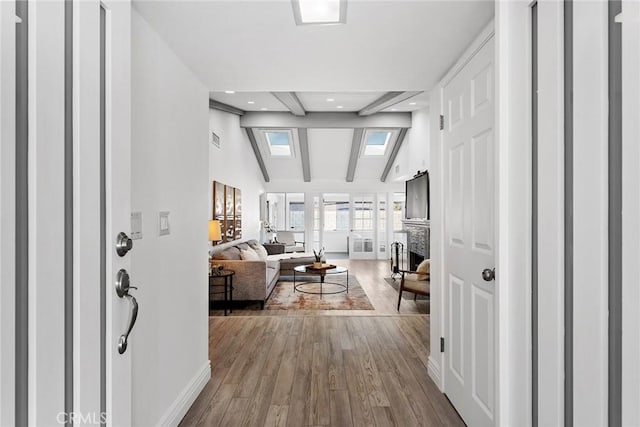 interior space featuring hardwood / wood-style floors, a fireplace, and vaulted ceiling with skylight