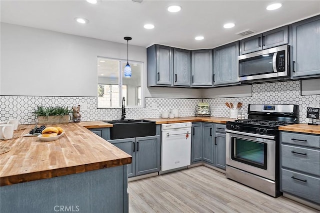 kitchen featuring sink, wooden counters, gray cabinets, pendant lighting, and stainless steel appliances