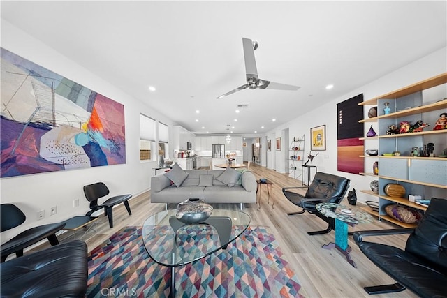 living area featuring ceiling fan, light wood finished floors, and recessed lighting