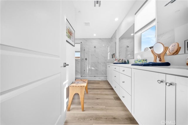 bathroom with vanity, an enclosed shower, and hardwood / wood-style flooring