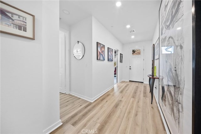 hallway featuring recessed lighting, light wood-style flooring, and baseboards