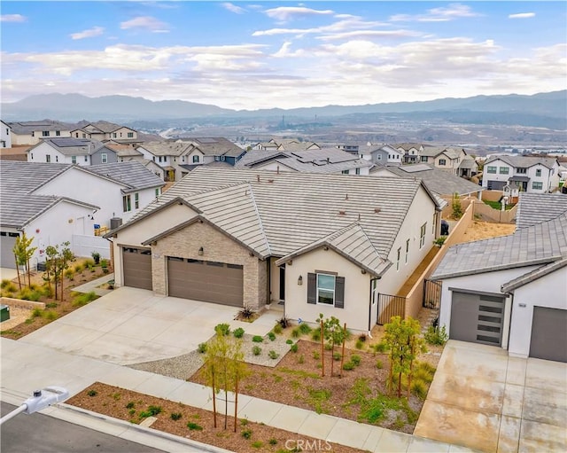 view of front of property with concrete driveway, an attached garage, fence, and a residential view