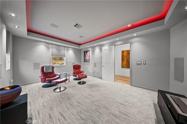 living area featuring recessed lighting, carpet floors, visible vents, baseboards, and a raised ceiling