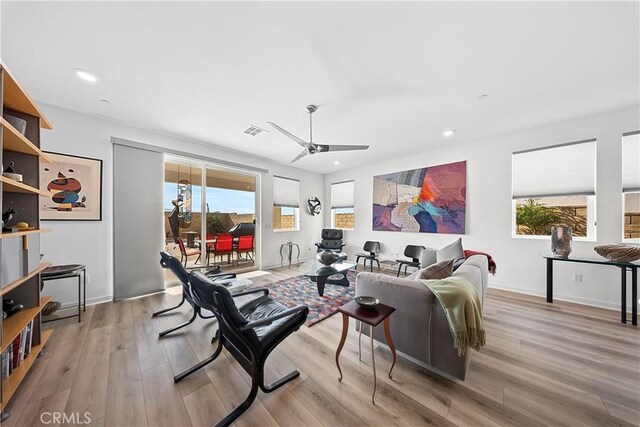 living room with light hardwood / wood-style floors and ceiling fan