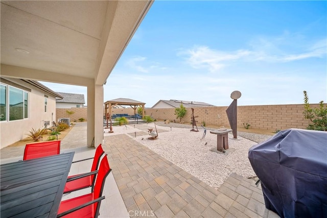 view of patio with a fenced backyard, a fire pit, area for grilling, and a gazebo