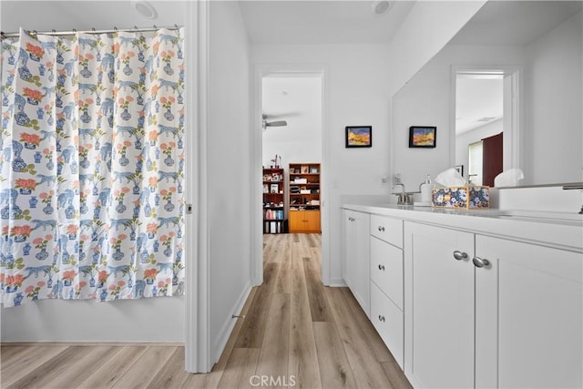 full bath featuring a shower with curtain, wood finished floors, and vanity