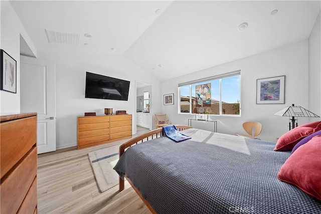 bedroom with lofted ceiling and light hardwood / wood-style floors