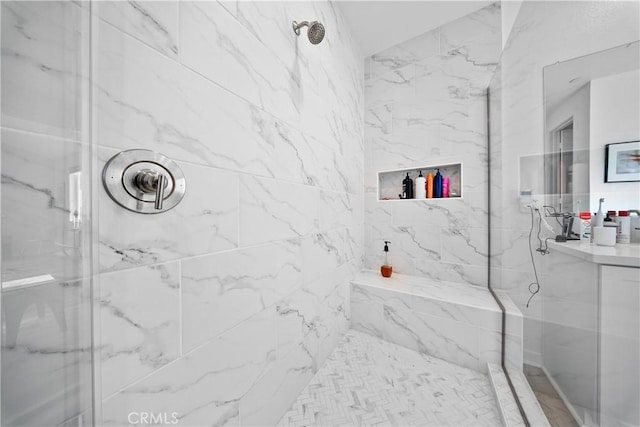 bathroom featuring a marble finish shower