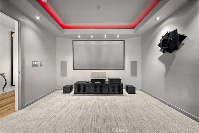 cinema with a raised ceiling and baseboards