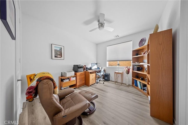 office space featuring visible vents, light wood-type flooring, and a ceiling fan