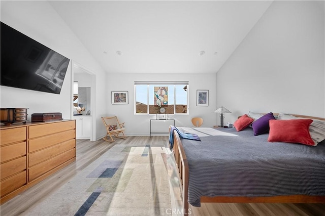 bedroom featuring lofted ceiling and light hardwood / wood-style flooring