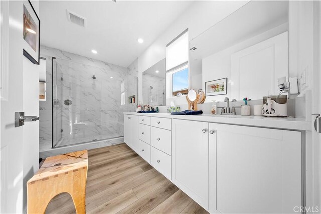 bathroom featuring vanity, wood-type flooring, and walk in shower