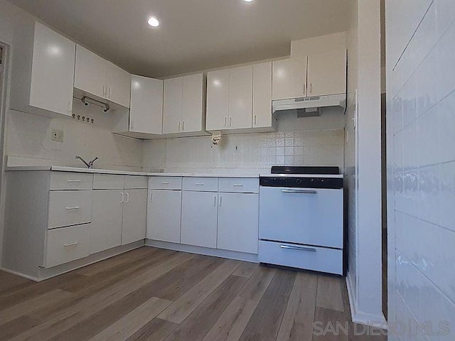 kitchen featuring decorative backsplash, white cabinets, white range with electric stovetop, and light hardwood / wood-style flooring