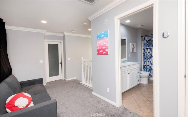 hall featuring sink, crown molding, and light colored carpet