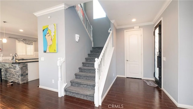 stairway with crown molding, wood-type flooring, and sink