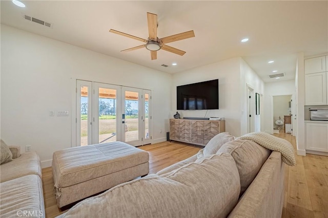 living room with ceiling fan, french doors, and light wood-type flooring