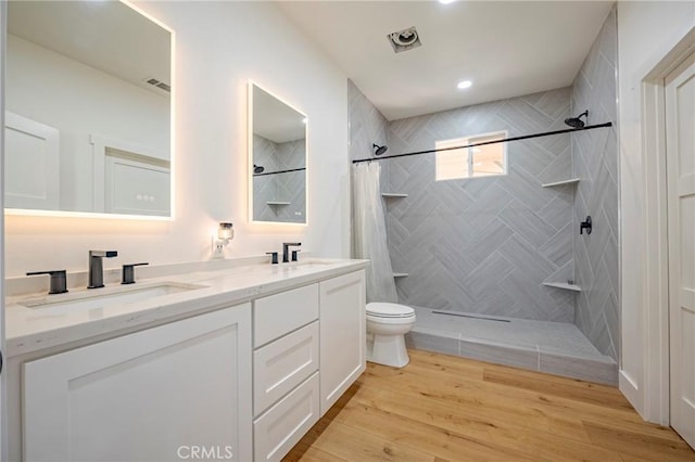 bathroom featuring curtained shower, hardwood / wood-style flooring, toilet, and vanity