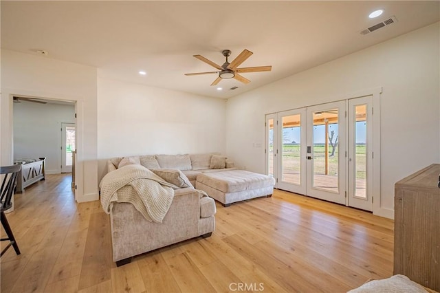 living room featuring light hardwood / wood-style floors, french doors, and a healthy amount of sunlight