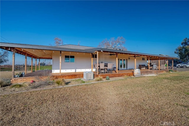 rear view of property featuring a lawn, a patio, cooling unit, and french doors