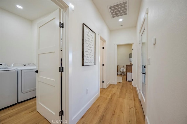 corridor featuring light wood-type flooring and washer and dryer