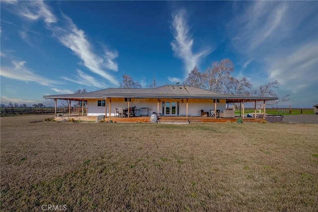 back of house with a patio area and a lawn