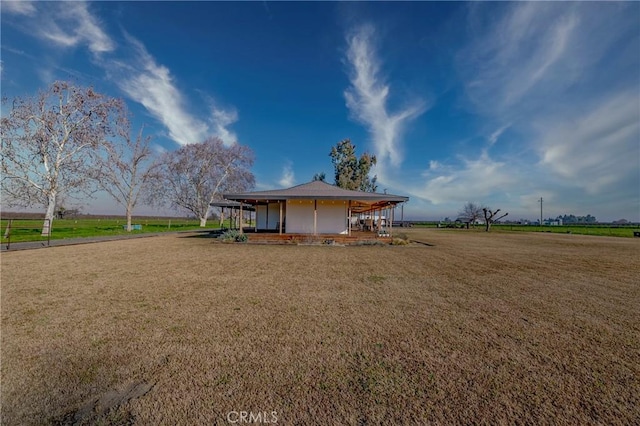 exterior space featuring a lawn and a rural view