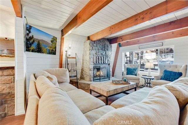 living room featuring a fireplace, wood walls, hardwood / wood-style flooring, and beamed ceiling